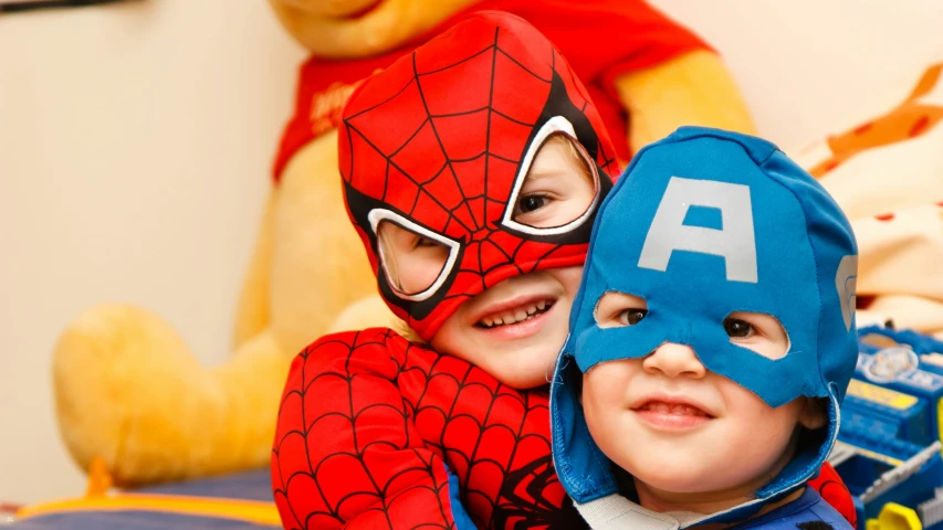 two small boys with spiderman and captain america masks