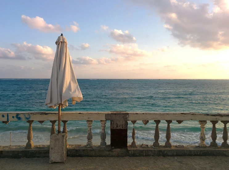 an open umbrella sitting outside near the water