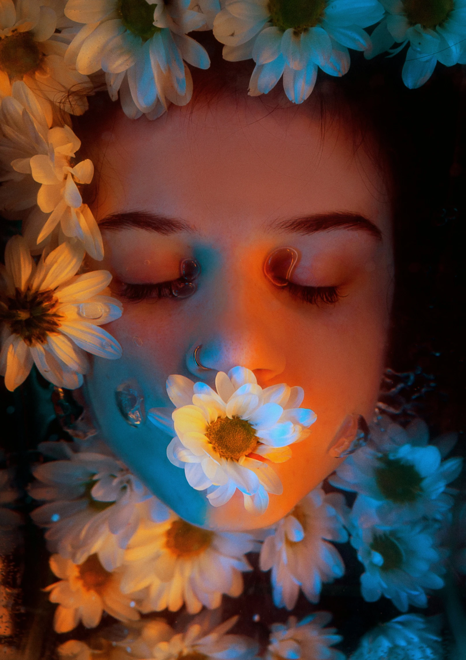 a woman with eyes closed behind flowers