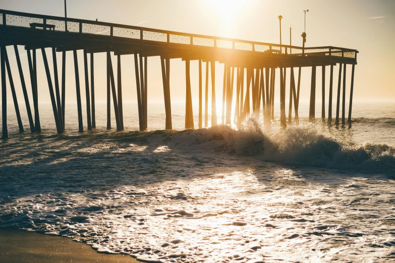 the sun is rising near a body of water