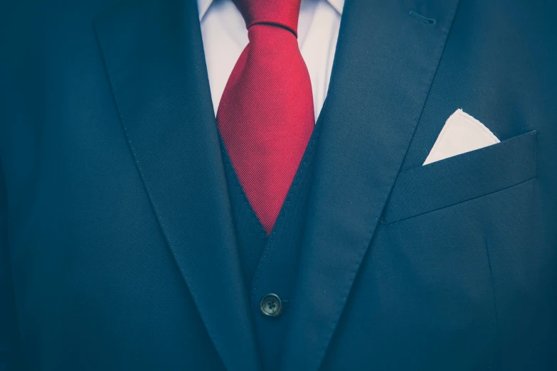 the businessman has a bright red tie and dark blue suit