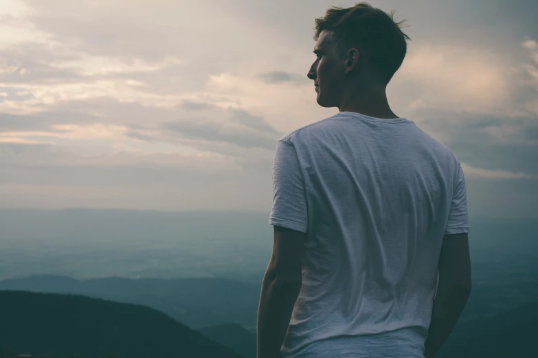 a man looks into the distance as the sun sets