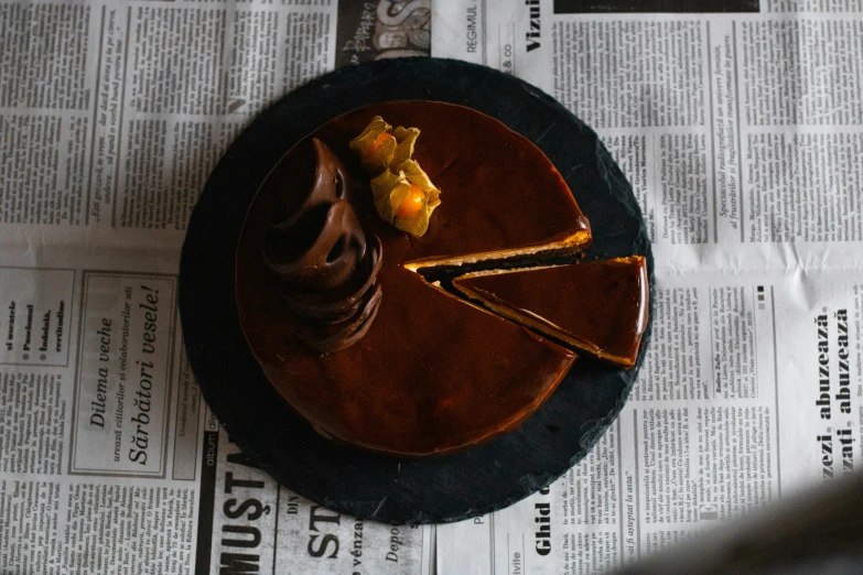 a chocolate dessert with a piece missing from the center on newspaper