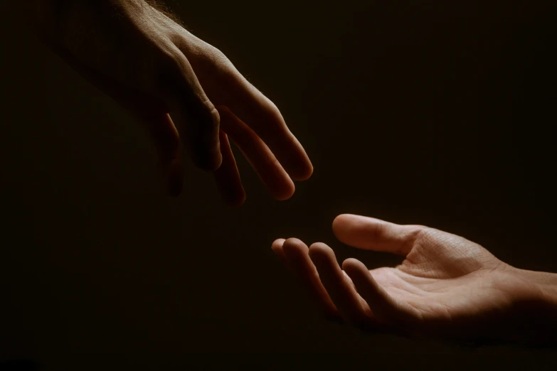 two hands are touching and reaching for each other