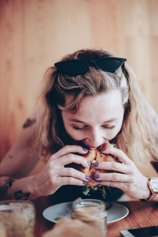 a person that is eating some food out of her hands
