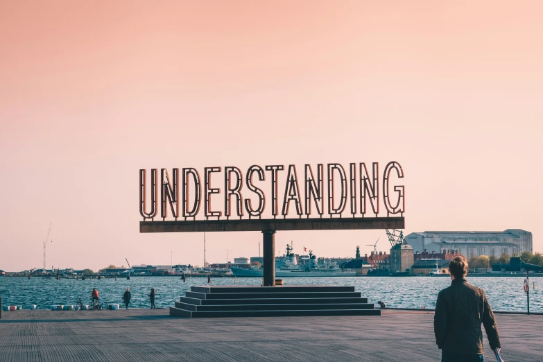 man in front of a large sign with writing on it