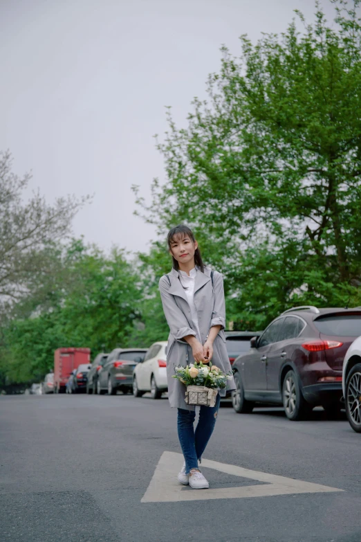 woman with flower in basket standing near parking lot