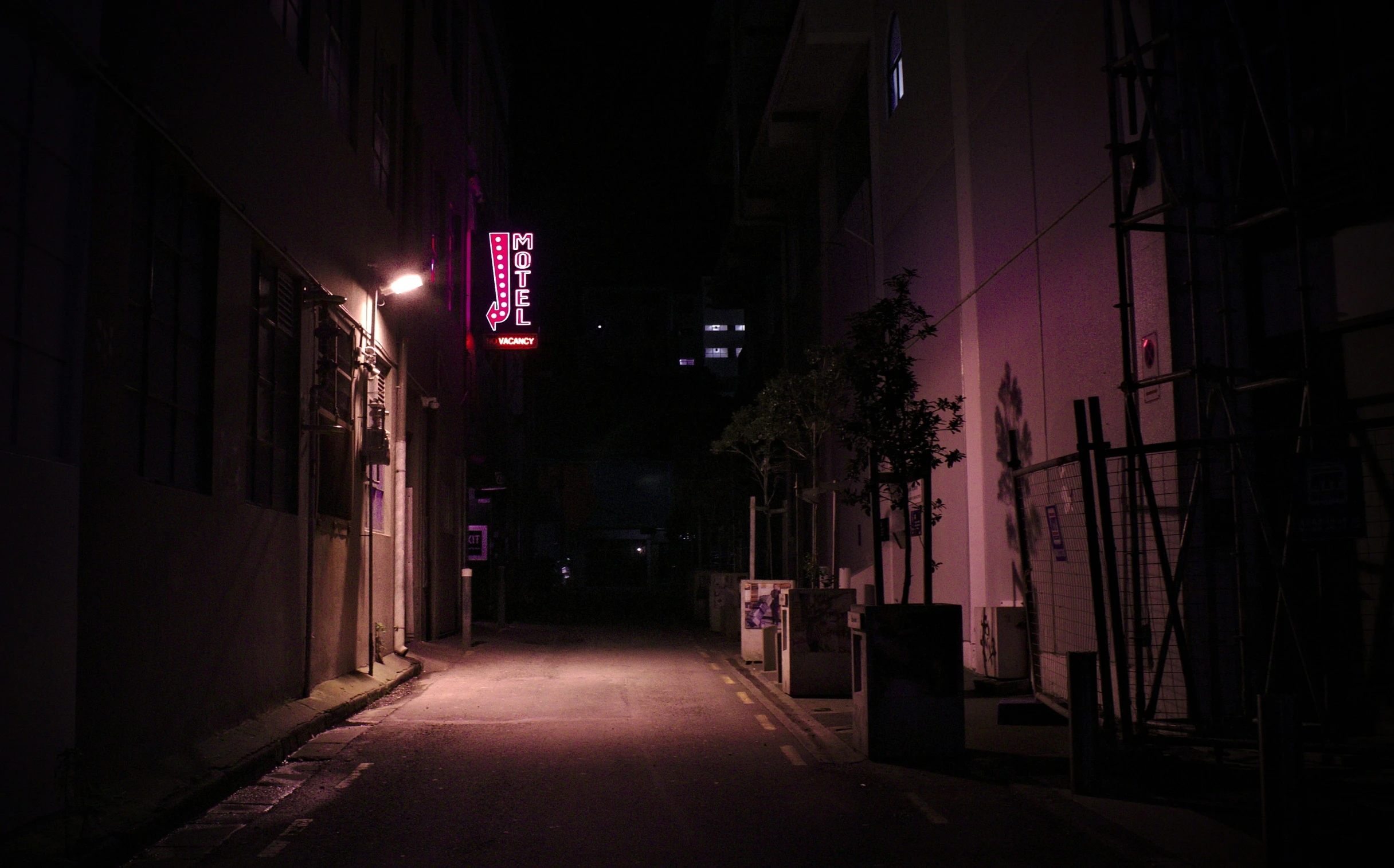 a street at night with a bright neon sign on it