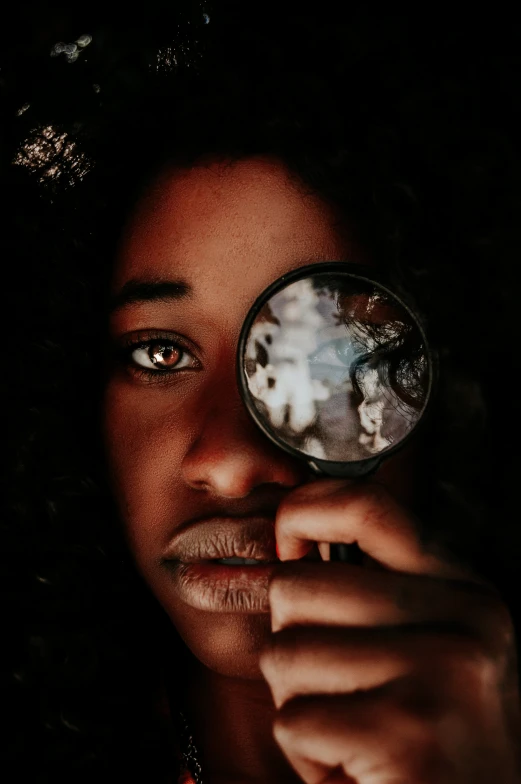 a woman holding a magnifying glass over her eye