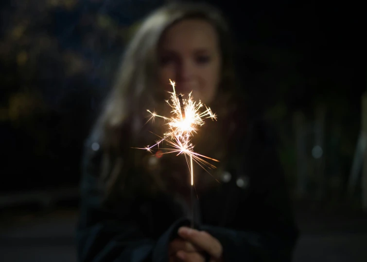 a  holding a sparkler in her hand