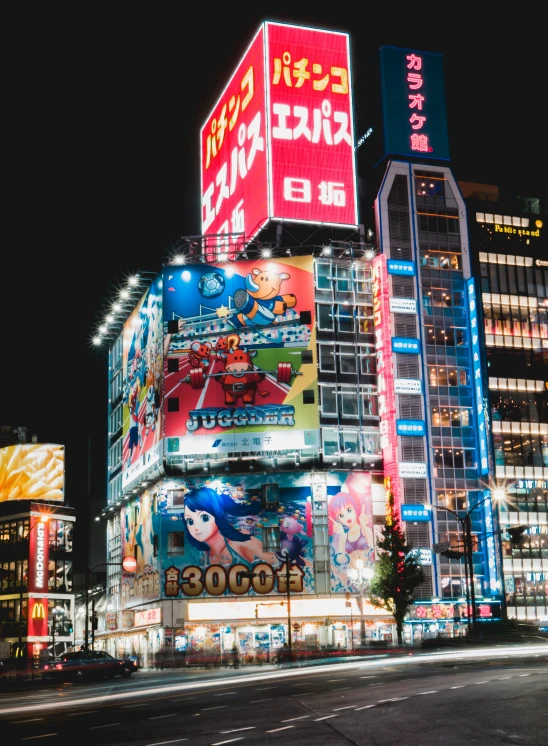 a city at night with lighted buildings and billboards on the street