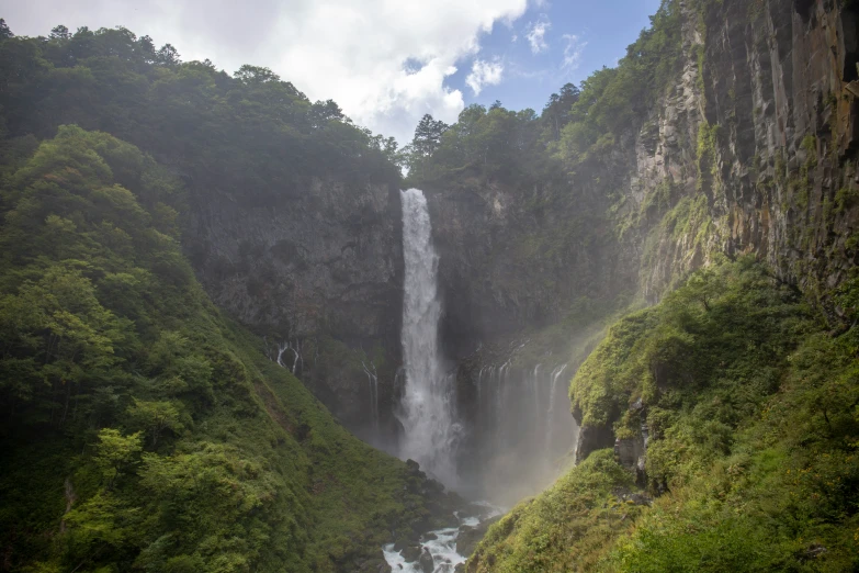 a waterfall flows into a small river below it