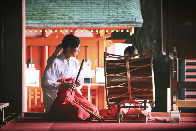 woman in traditional japanese dress sitting on floor next to chair