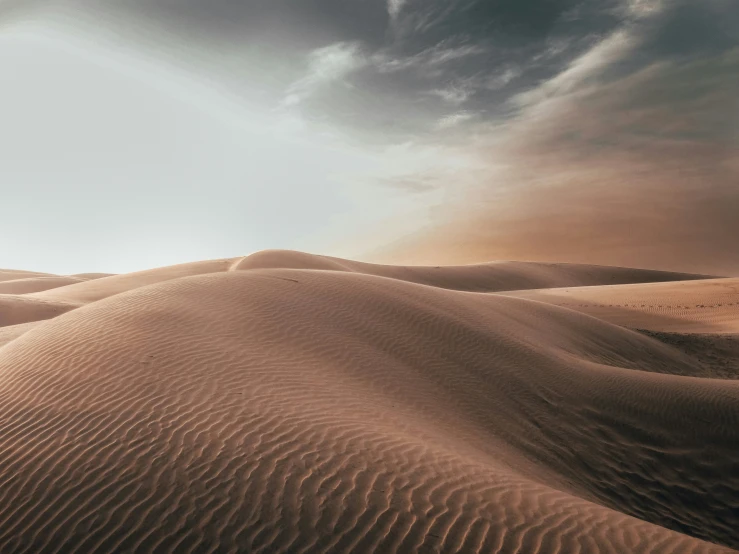 an arid desert with dark clouds and light