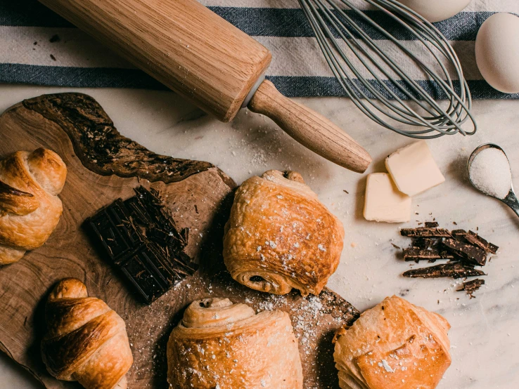 fresh pastries are sitting on a  board next to er and other ingredients