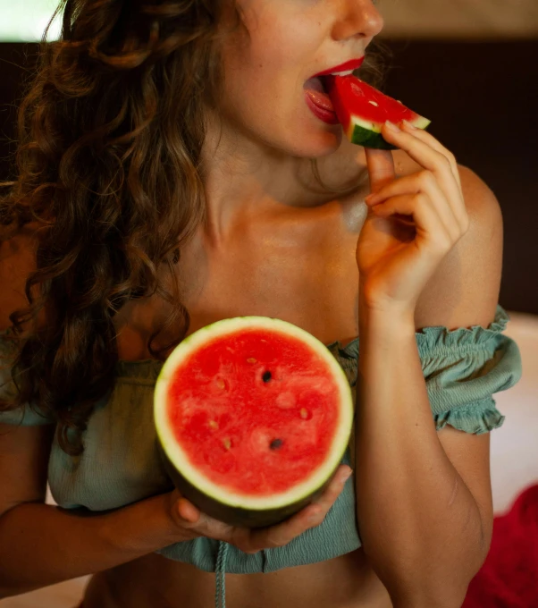 a girl eating watermelon in a bikini