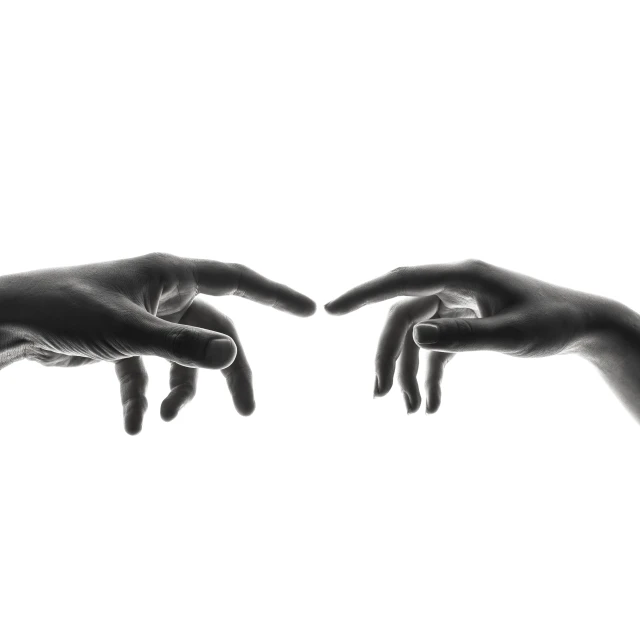 an artistic black and white picture of two hands touching each other