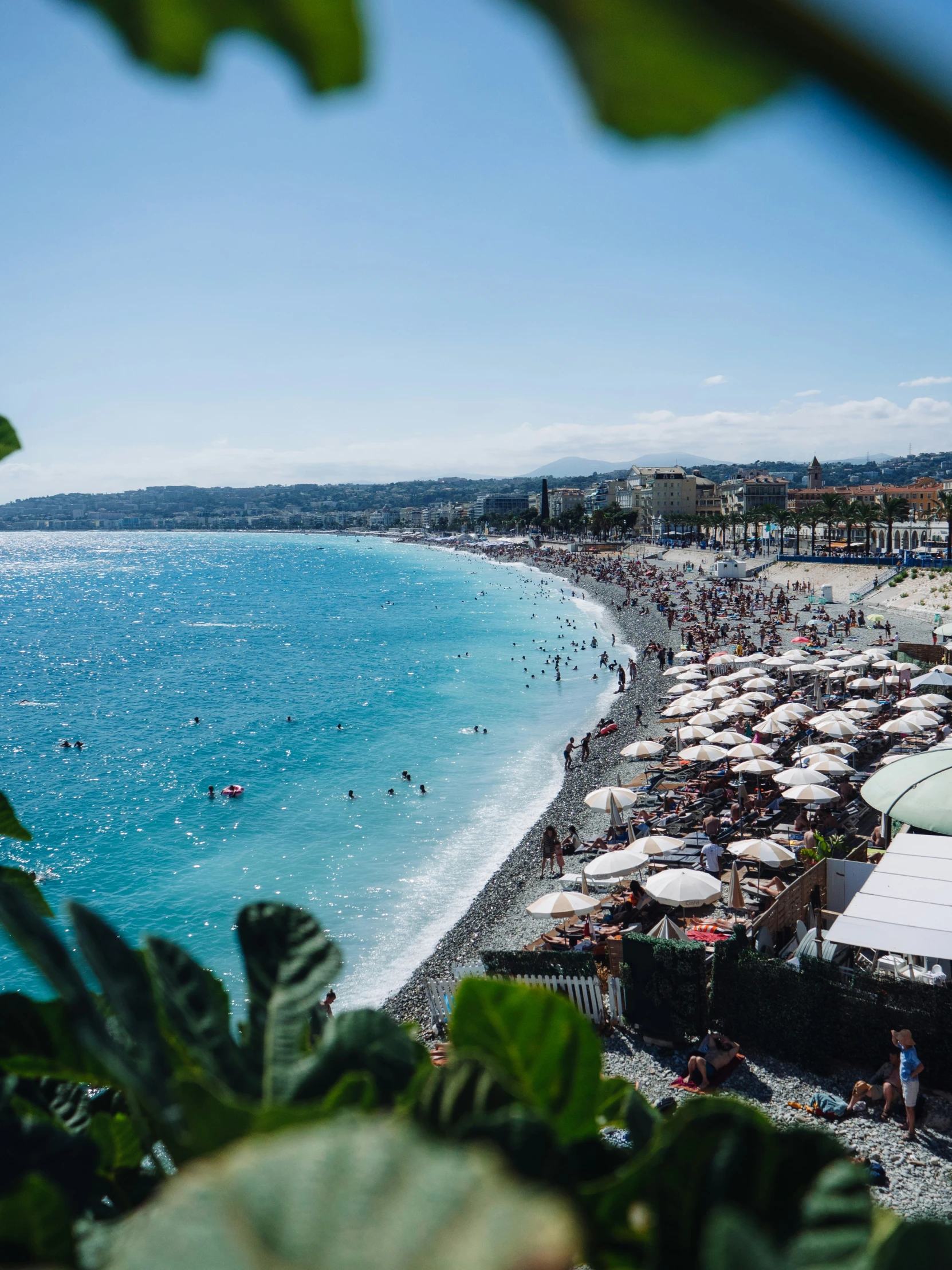 a view of people at the beach from a hill above