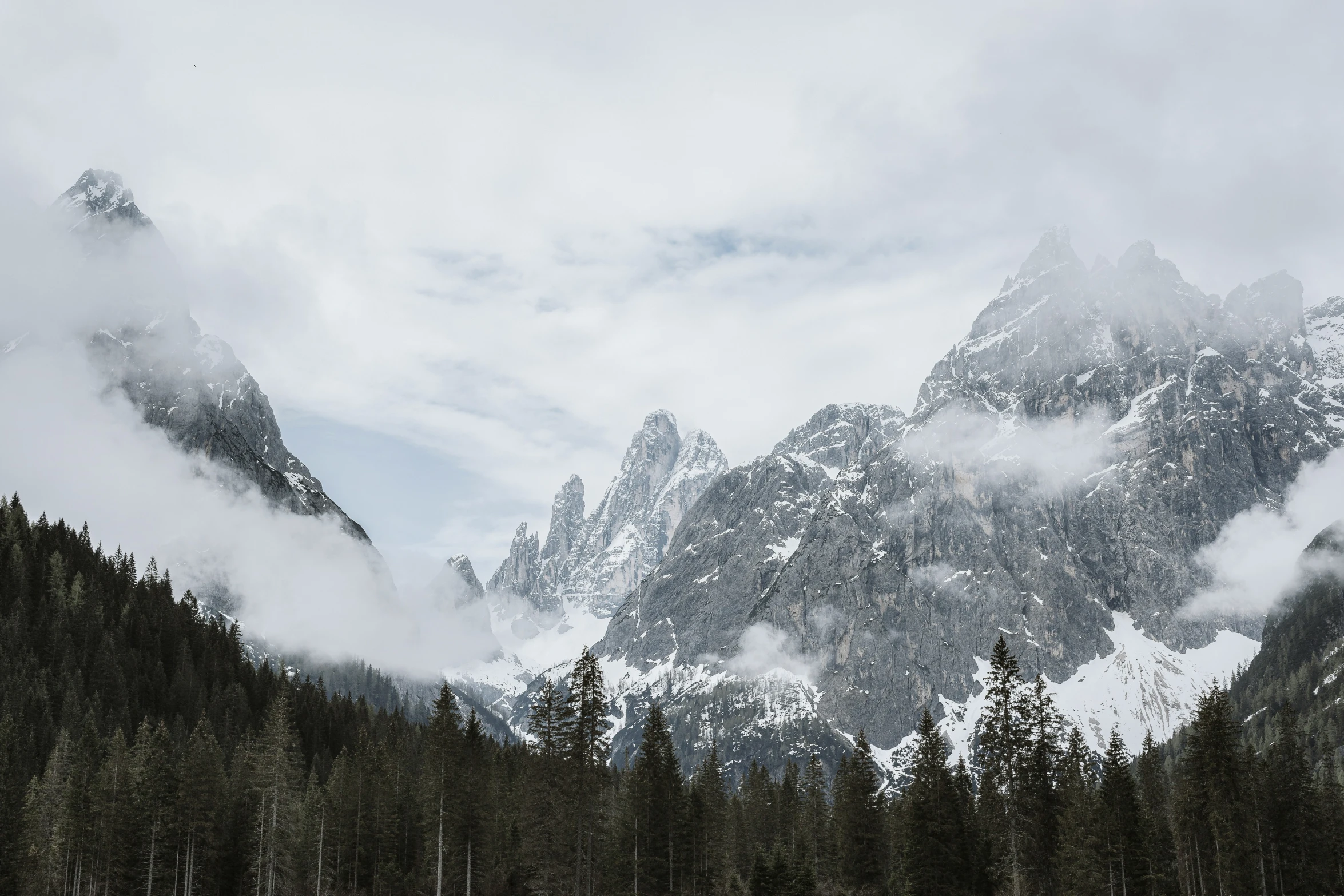 a mountain range covered in mist and clouds