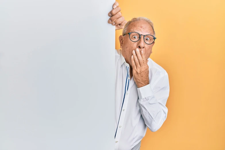 an old man holding a sign up in front of his face