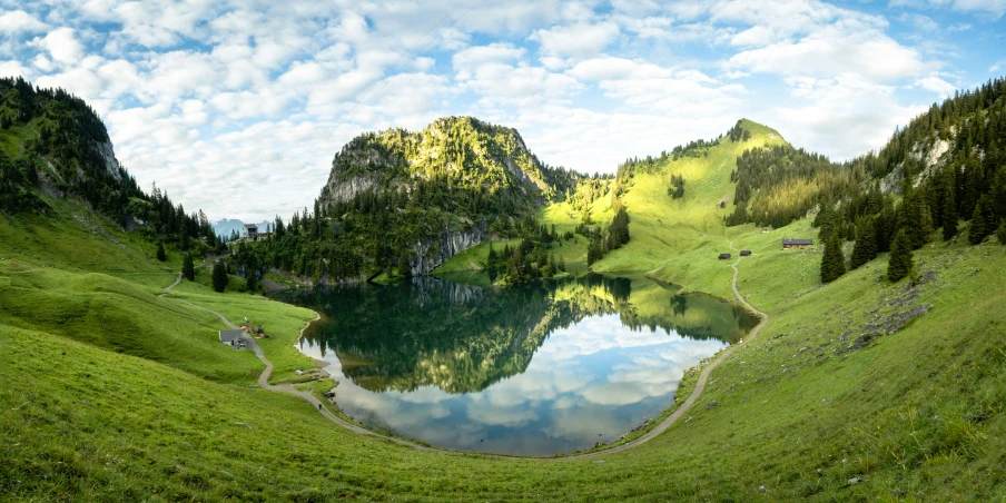 an alpine landscape shows a lake and mountain range