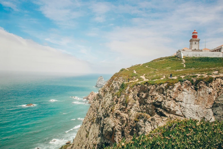 an ocean view and lighthouse on the top of a cliff