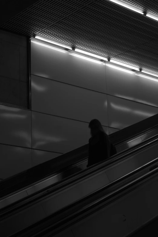 person riding down an escalator in the city