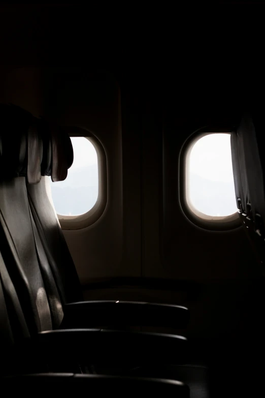 view of airplane and seat with a person standing up looking out the window