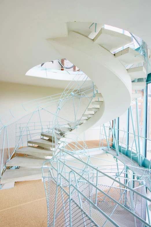 a curved staircase with glass walls and metal railings