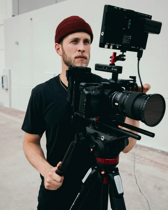 a man in a black t - shirt with a red camera