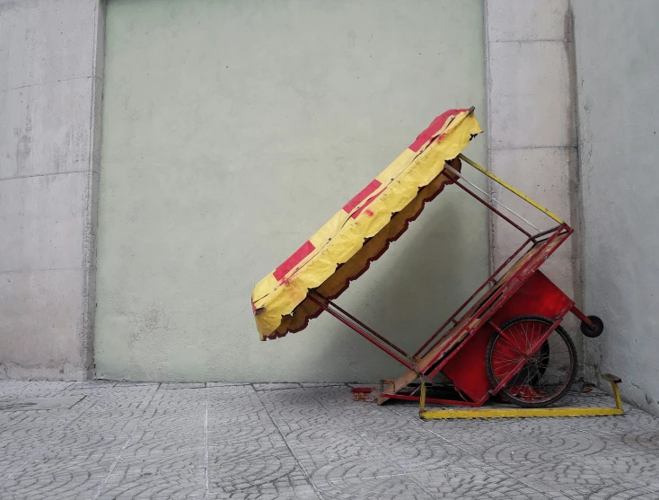 a red and yellow cart with a dog on it