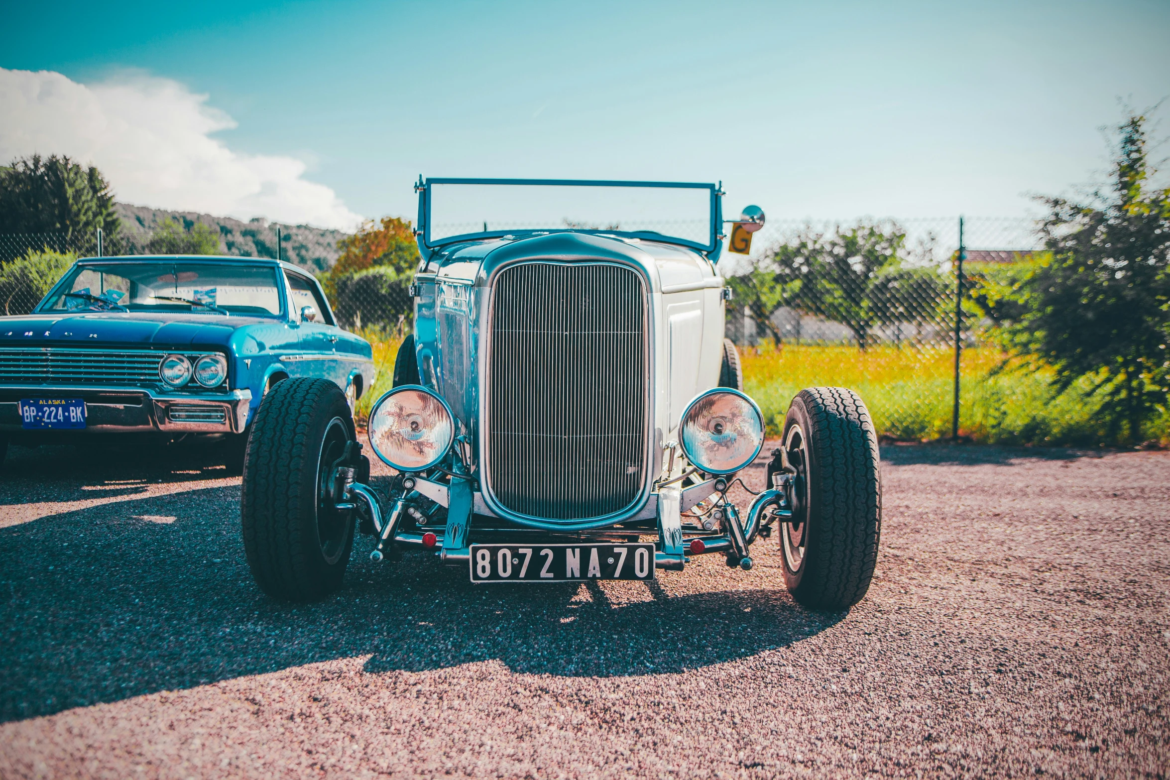 an old time truck sitting next to a couple of classic cars