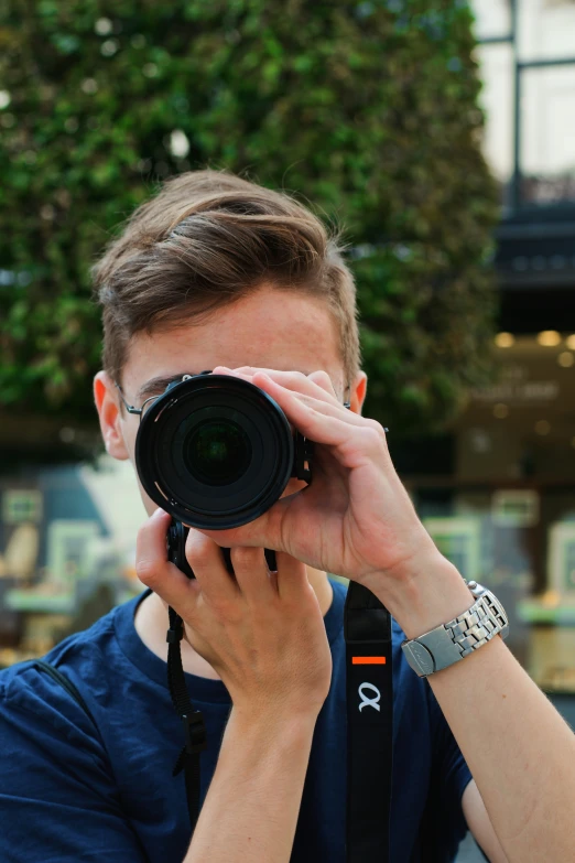 the man is holding up a camera to take a picture