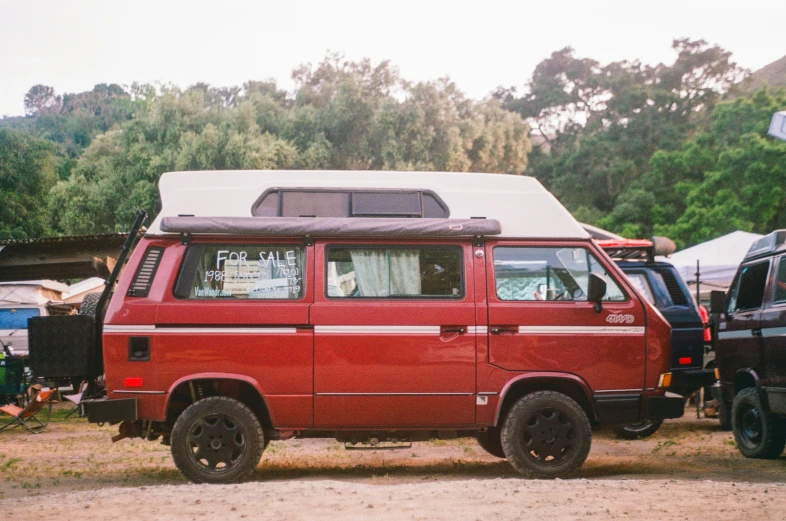 a van with a camper on top of it near some trees