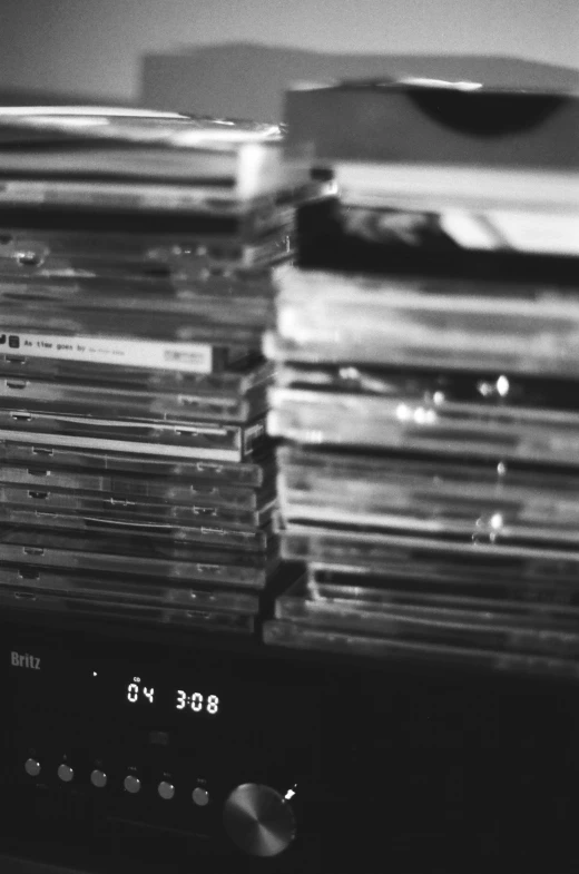 a pile of cd discs on top of a radio