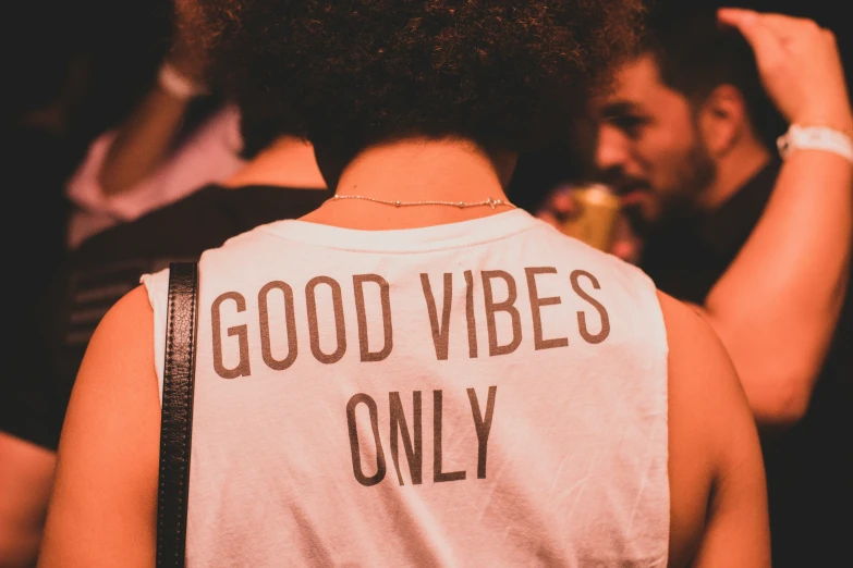 a man wearing a white vest reading i good vibes only