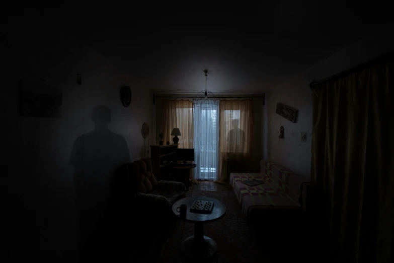 dark room with furniture and a person in it