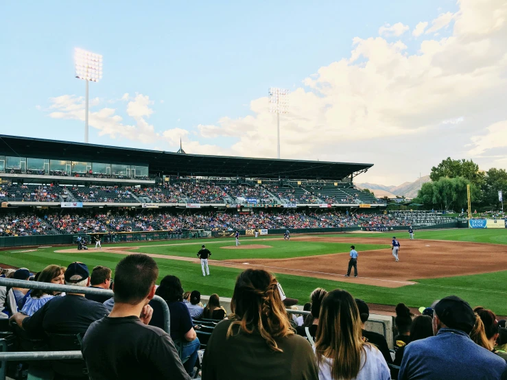 a large crowd stands at home plate watching a baseball game