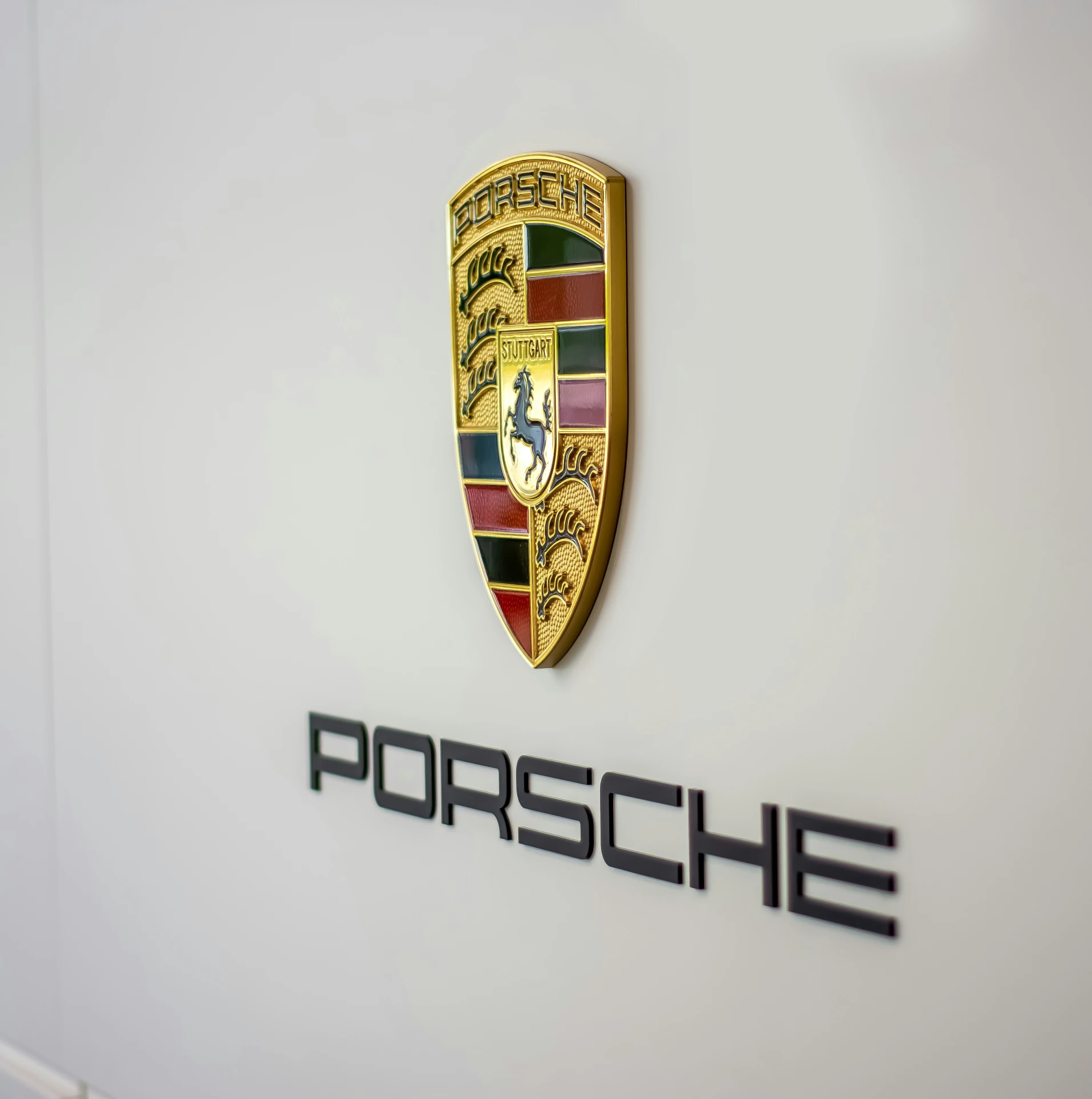the porsche badge is shown on a white wall