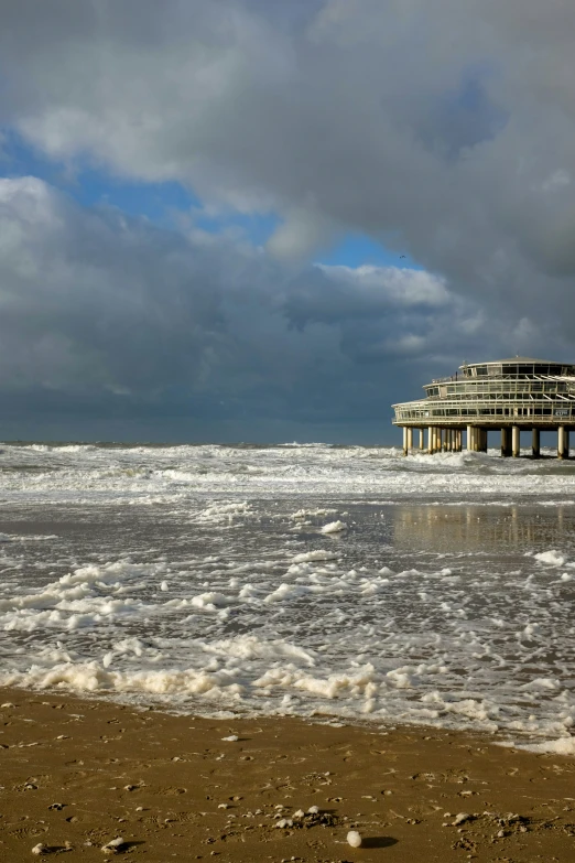 the waves are in front of the pier and beach