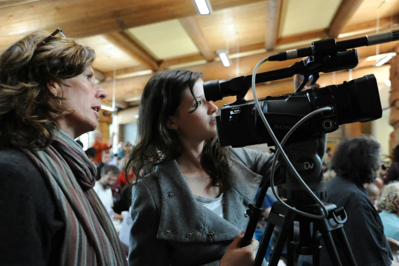 two women are standing in front of a camera