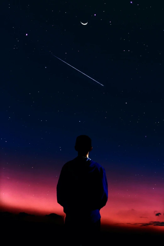 a man with his back to the camera and looking up at a star