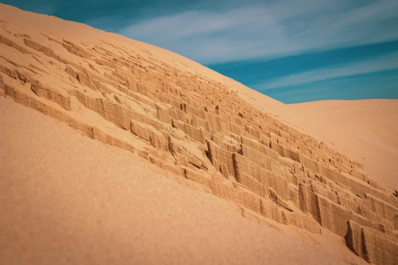 an abstract image of sand dunes and blue sky