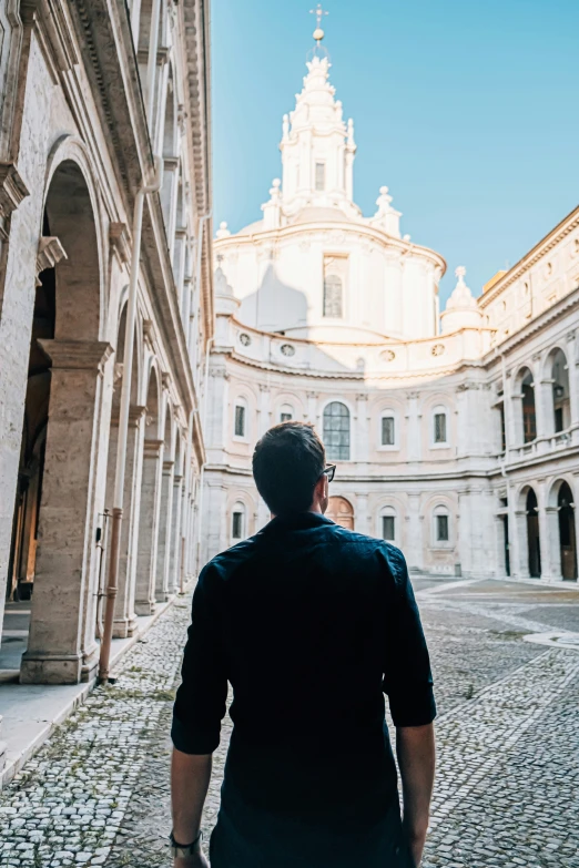 a man walking down the middle of a cobblestone walkway