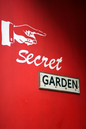 a red sign on the side of a building that says secret garden