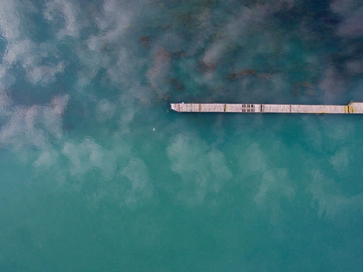 an empty long plank floating on top of the ocean