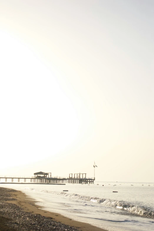 a large body of water next to a wooden pier