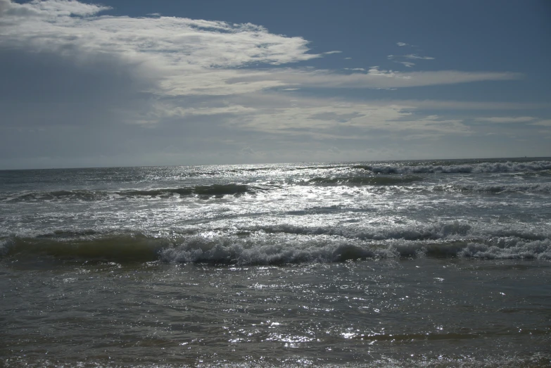 a calm ocean and waves under a blue sky