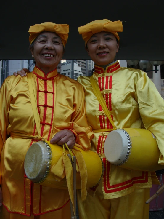 two men in yellow are wearing asian outfits