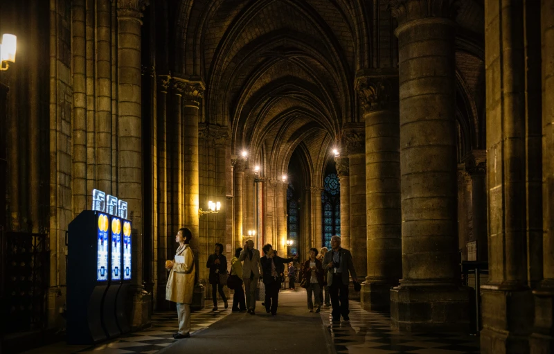 a group of people walking along a building's cathedral